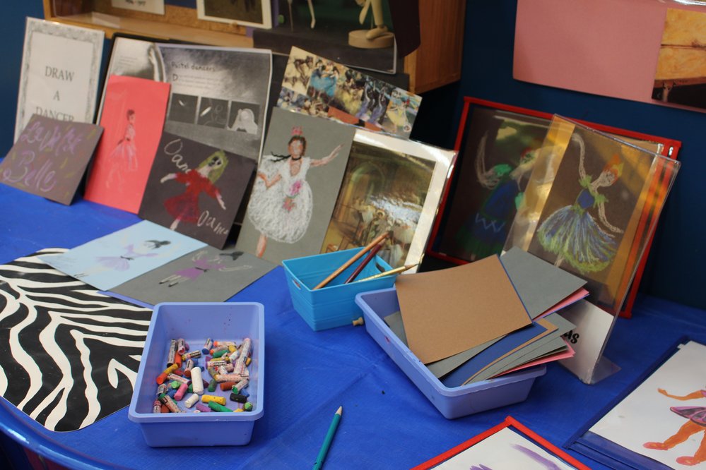 Table with different art supplies and drawings of ballerinas